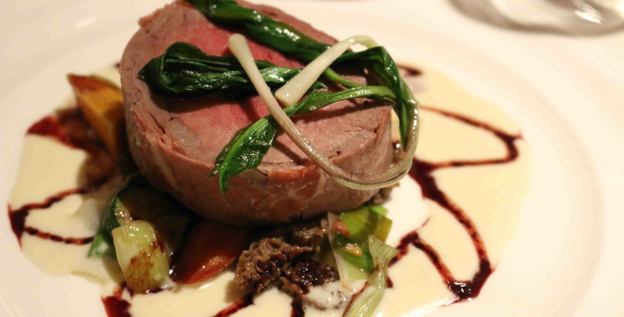 Prosciutto Wrapped Slow Roasted Prime Tenderloin, Early Spring Vegetables, Smokey Shallot Cream and Red Wine Syrup