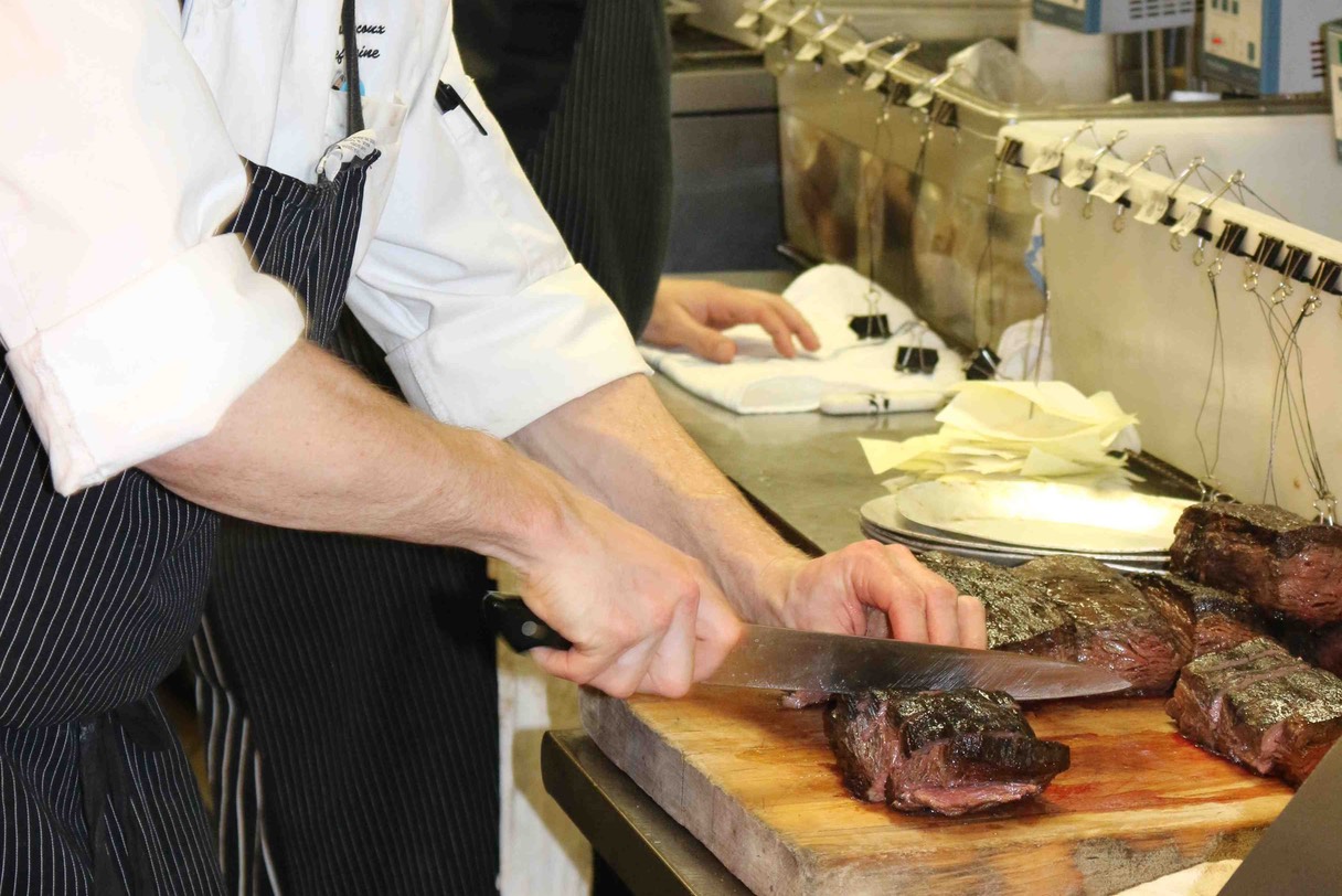 Chef de Cuisine Ryan Marcux cutting Spinalis